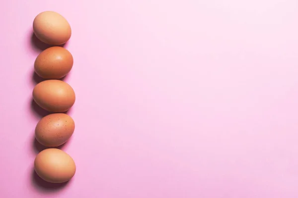 분홍색 배경의 갈색 달걀. — 스톡 사진