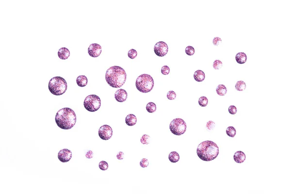 Purple glitter nail polish drops isolated on white.