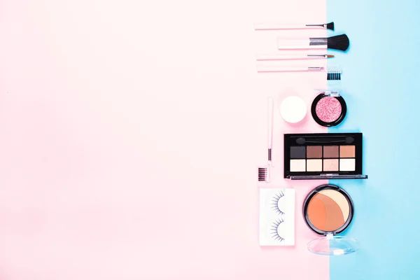 Make-up Frau Essentials auf rosa und blauen Hintergrund. — Stockfoto