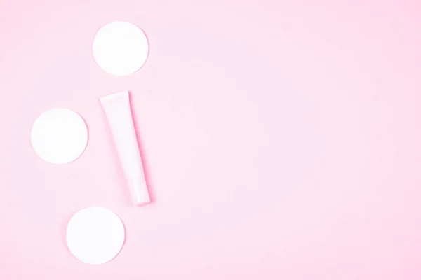 Tubo cosmético rosa e almofadas de algodão branco . — Fotografia de Stock