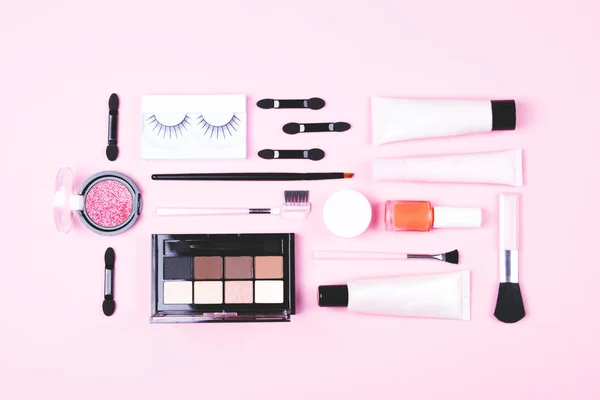 Základy ženské make-up na růžovém pozadí. — Stock fotografie