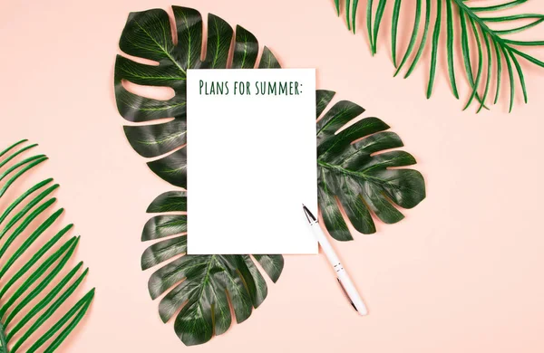 Exotic plants and note pad on pale pink background. — Stock Photo, Image