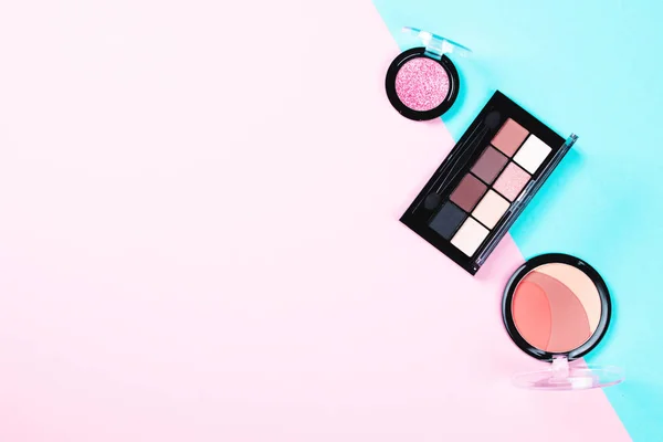 Make-up vrouw Essentials op roze en blauwe achtergrond. — Stockfoto