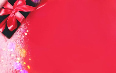 Kırmızı arkaplanda siyah hediye kutusu.