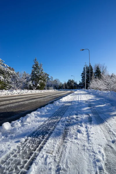 Mavi gökyüzünün altında kışın güzel karlı yol