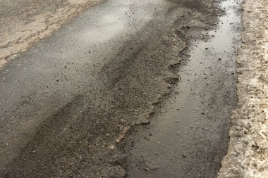 Eski yolu. Büyük çukurlar ve çukurların bulutlu hava, kalın karanlık bulutlar gökyüzünde kavramı karayolu. Zor yoldan, seçim sembolü