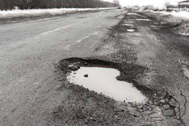 Eski yolu. Büyük çukurlar ve çukurların bulutlu hava, kalın karanlık bulutlar gökyüzünde kavramı karayolu. Zor yoldan, seçim sembolü