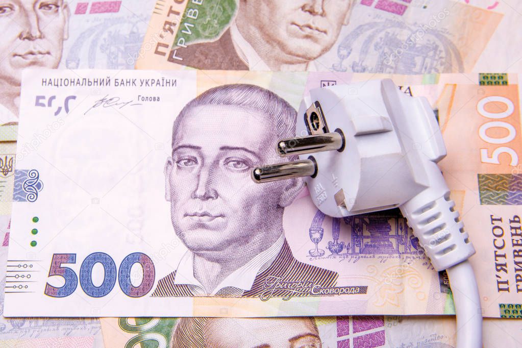 electro-fork with a wire close-up lies on the banknotes of Ukrainian money in hryvnias