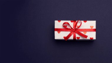 beyaz zemin üzerinde bir şerit izole ile görüntü ile bir hediye kutusu kalplerin bağlıdır. Sevgililer günü kutlama kavramı