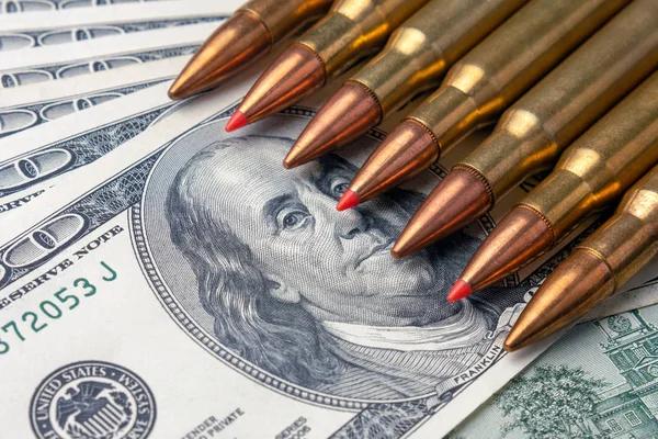 bullets close-up lie on the bills of 100 dollars. Concept of copy space currency and national defense