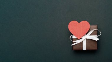 Hediyelik Sevgililer günü için kırmızı bir kutu bir resim, bir kalp ile sarılı. Gölge beyaz zemin üzerine izole