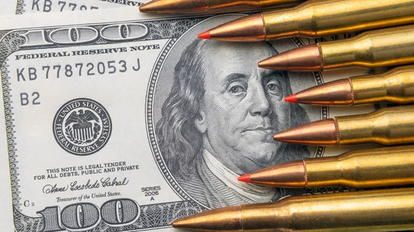 bullets close-up lie on the bills of 100 dollars. Concept of copy space currency and national defense