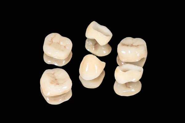 Ceramicznych koron dentystycznych i oklein. Izolowanie na czarnym tle — Zdjęcie stockowe