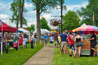 Twinsburg, Oh - 9 Haziran 2018: Ziyaretçi satıcı için kulübeler A Taste of Twinsburg, açık mutfak toplamak ve Sanat Festivali düzenlenen Yaz aylarında bir Cumartesi şehir meydanında.