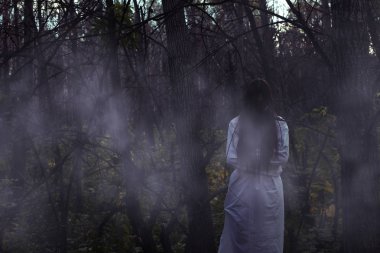 Kasvetli bir ormanda ölü bir kız halloween portresi. Hayalet kız Cadılar Bayramı gecesi bir kasvetli karanlık ormanda