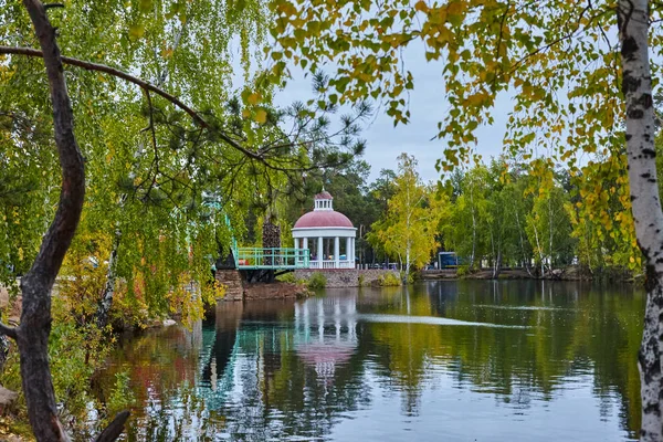 Chelyabinsk, Yu sonra Park adında. A. Gagarin. Sarı yapraklar ile sonbahar parkta gölet yakınındaki rotunda görünümünü.