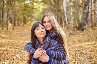 Anne ve kızı sonbahar ormandaki portresi. Güzel genç kadın ve genç sonbahar park.