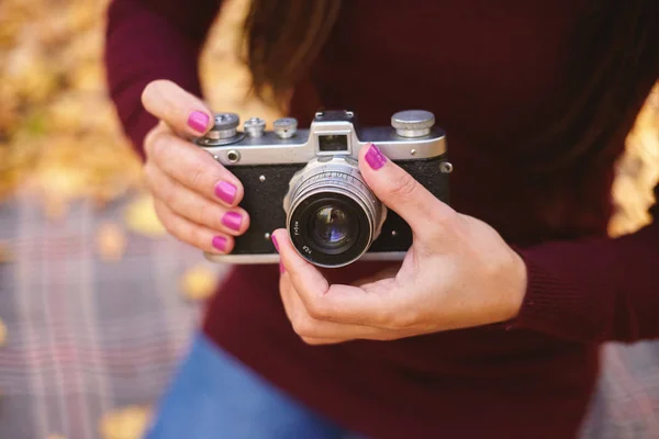 Vintage camera in the hands of a woman. Girl holding a vintage camera.