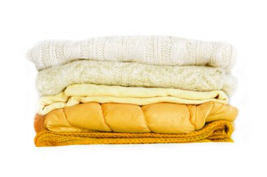 Beyaz arka plan üzerinde izole sarı kış giysileri yığını. Beyaz arka plan üzerinde sıcak rahat elbise yığını.