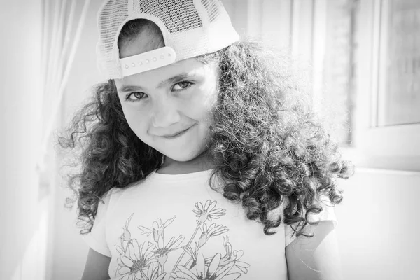 Een Klein Curly Haired Meisje Een Cap Een Zwart Wit — Stockfoto