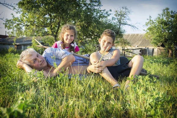 草の庭の村の夏は孫と幸せの祖父 — ストック写真