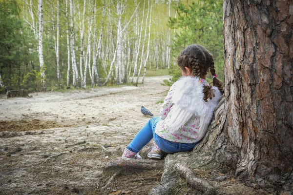 V létě je malý anděl opřený o strom v lese — Stock fotografie