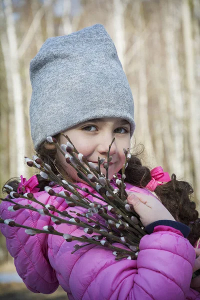 In het voorjaar in het bos staat een klein meisje met een boeket — Stockfoto