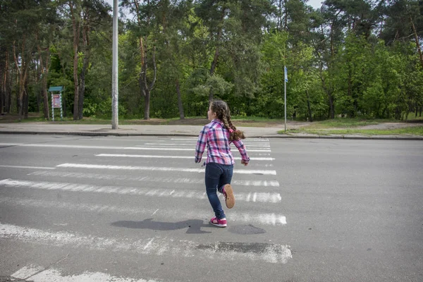 Το καλοκαίρι, στο δρόμο, ένα μικρό κορίτσι διασχίζει το δρόμο για — Φωτογραφία Αρχείου