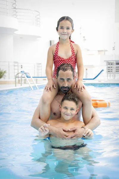 In the summer in the pool, dad with children plays in the pool. — Stock Photo, Image