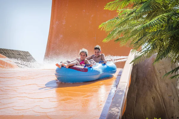 No verão, em um dia ensolarado brilhante, em um parque aquático, um irmão — Fotografia de Stock