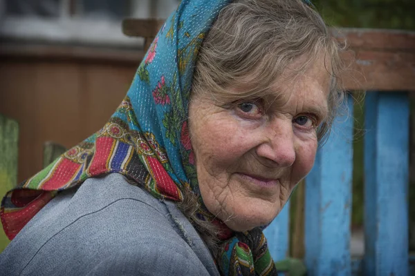 W lecie, na ulicy, stara babcia w szalik. Clo — Zdjęcie stockowe