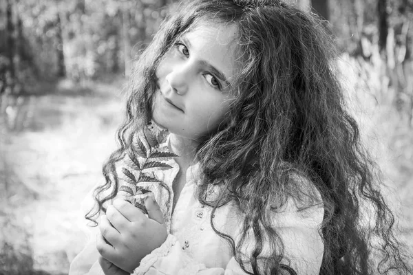 Na floresta de outono, uma menina bonita pequena com seu cabelo é ho — Fotografia de Stock