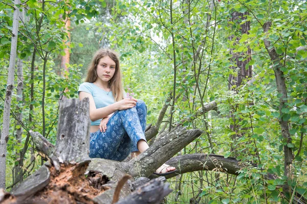 Zomer Zit Een Meisje Een Bos Een Omgevallen Dennenboom — Stockfoto