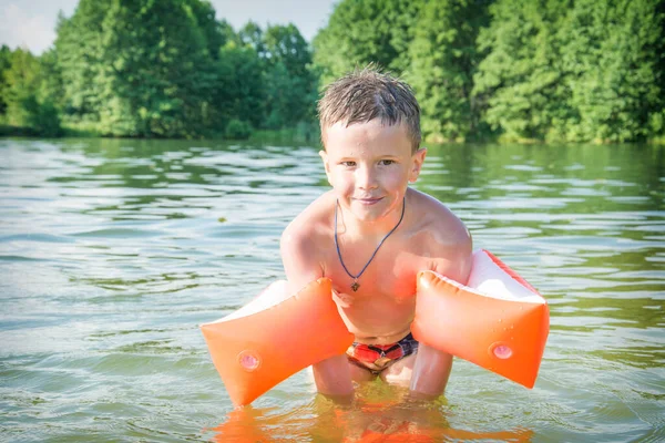 Latem Słoneczny Dzień Chłopiec Nadmuchiwanych Opaskach Pływa Jeziorze — Zdjęcie stockowe