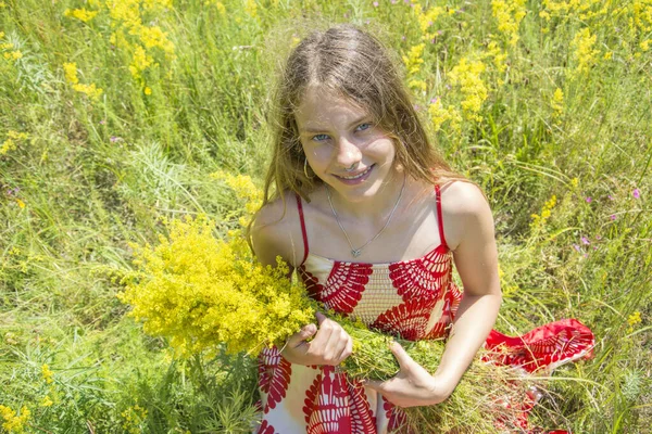 Latem Słoneczny Dzień Kwitnącym Polu Dziewczyna Stoi Jasnoczerwonej Sukience Która — Zdjęcie stockowe