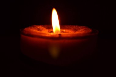 Karanlık bir arka plan üzerinde sarı alev kırmızı mum yakma.