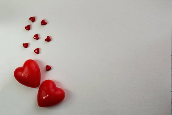 Valentine card with heart decor on a white table. Top view with space for your greeting. Valentine's day decoration with copy space