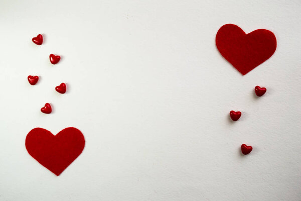 Valentine's day background with a lot of red hearts on a white background. Top view with space for your greeting.
