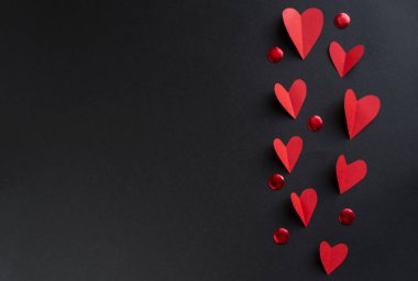 Valentine's day background with a lot of red hearts on a black background. Top view with space for your greetings clipart