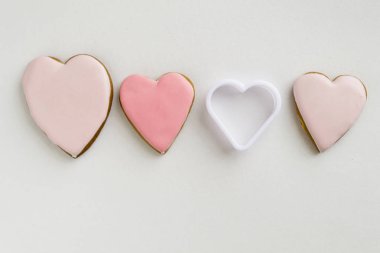 Pembe renkli gingerbread ve bal pastalar kurabiyeler. Bir kalp şeklinde. Hafif ahşap arka plan üzerinde. Çerçeve. Çerçeve. Metin için yer. Aşk, kavramı anneler günü, yemek, St. Valentine.