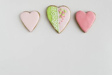 Frame. Place for text. The concept of love, mother's day, cooking, St. Valentine. Painted pink and colored, ginger and honey cakes and cookies. In the shape of a heart. On a light wooden background.