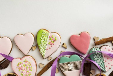 Zencefilli kurabiye pembe sır içinde. Pastane. Gingerbread bir kalp şeklinde. Metin için yer. Gingerbread desen arka plan. Tarçın ve kalpleri üzerinde beyaz bir arka plan ile.