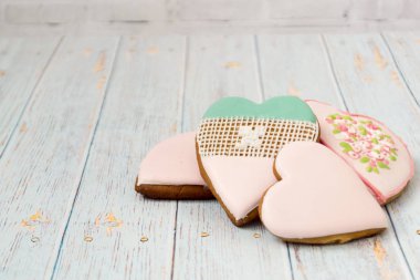 Boyalı gingerbread hafif ahşap arka plan üzerinde. Lezzetli kurabiyeler kalplerin bir forepe içinde. Pastane. Mesaj için geliyor. Aşk kavramı