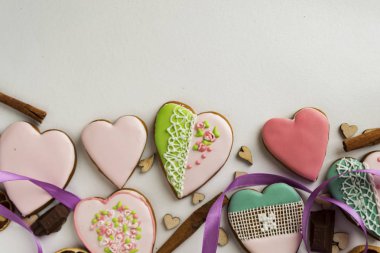 Boyalı gingerbread tarçın ve kalpleri üzerinde beyaz bir arka plan ile. Pastane. Gingerbread bir kalp şeklinde. Metin için yer. Gingerbread desen arka plan.