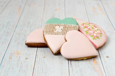Boyalı gingerbread hafif ahşap arka plan üzerinde. Lezzetli kurabiyeler kalplerin bir forepe içinde. Pastane. Mesaj için geliyor. Aşk kavramı