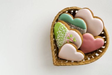 gösterişli pembe sır içinde. Pastane. Gingerbread bir kalp şeklinde. Metin için yer. Gingerbread desen arka plan. Hasır sepet içinde boyalı gingerbread.