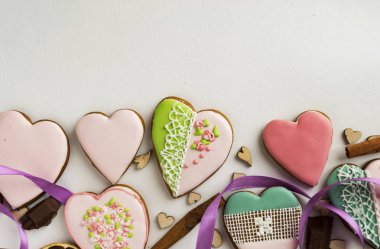 Boyalı gingerbread tarçın ve kalpleri üzerinde beyaz bir arka plan ile. gösterişli pembe sır içinde. Pastane. Gingerbread bir kalp şeklinde. Metin için yer. Gingerbread desen arka plan.