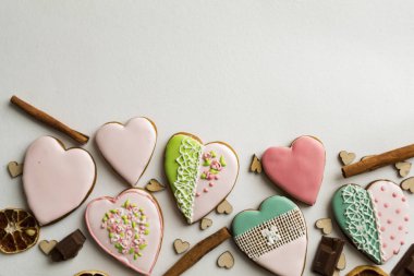 Boyalı gingerbread tarçın ve kalpleri üzerinde beyaz bir arka plan ile. gösterişli pembe sır içinde. Pastane. Gingerbread bir kalp şeklinde. Metin için yer. Gingerbread desen arka plan.