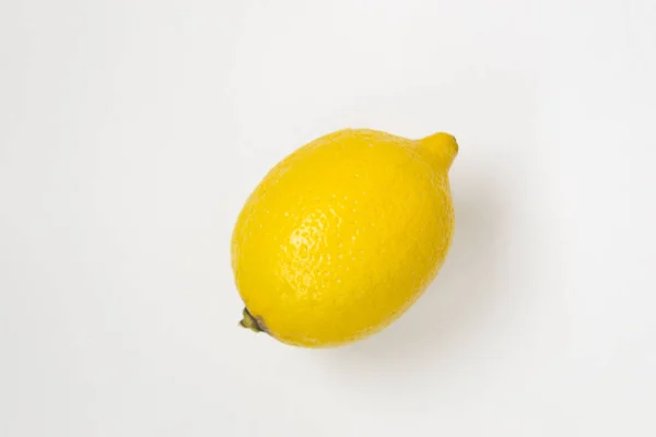 One yellow lemon on a white background, there is a place for text. — Stock Photo, Image