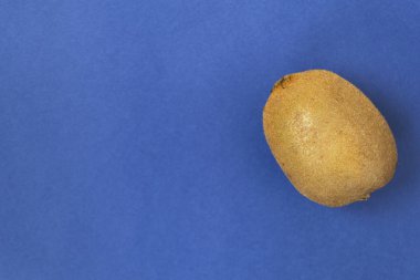 Sağlıklı beslenme kavramı. Mavi bir arka plan üzerinde tüm kivi. Yukarıdan görüntülemek.